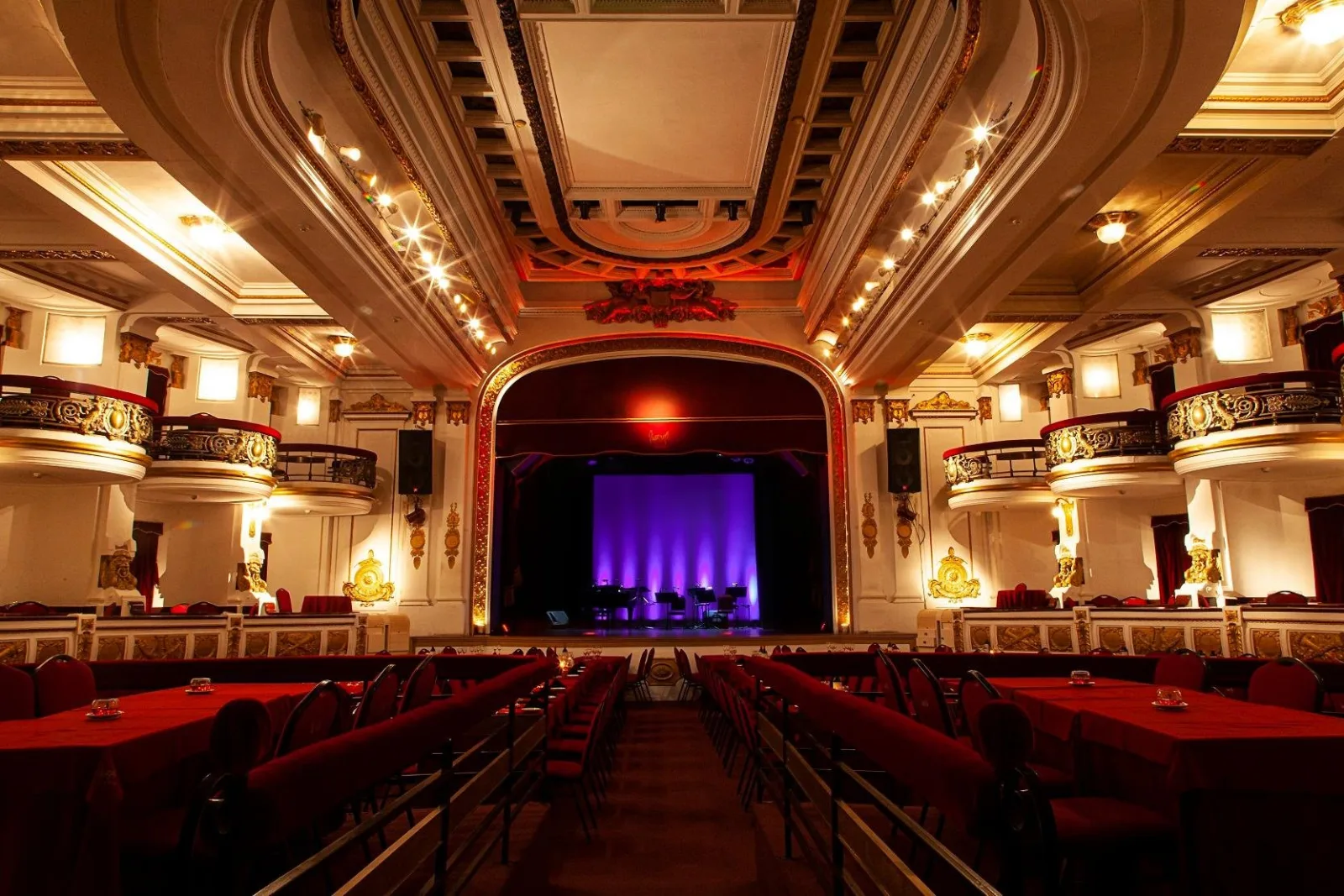 Tiered seating and dining tables facing the stage inside the Piazzolla Tango theatre