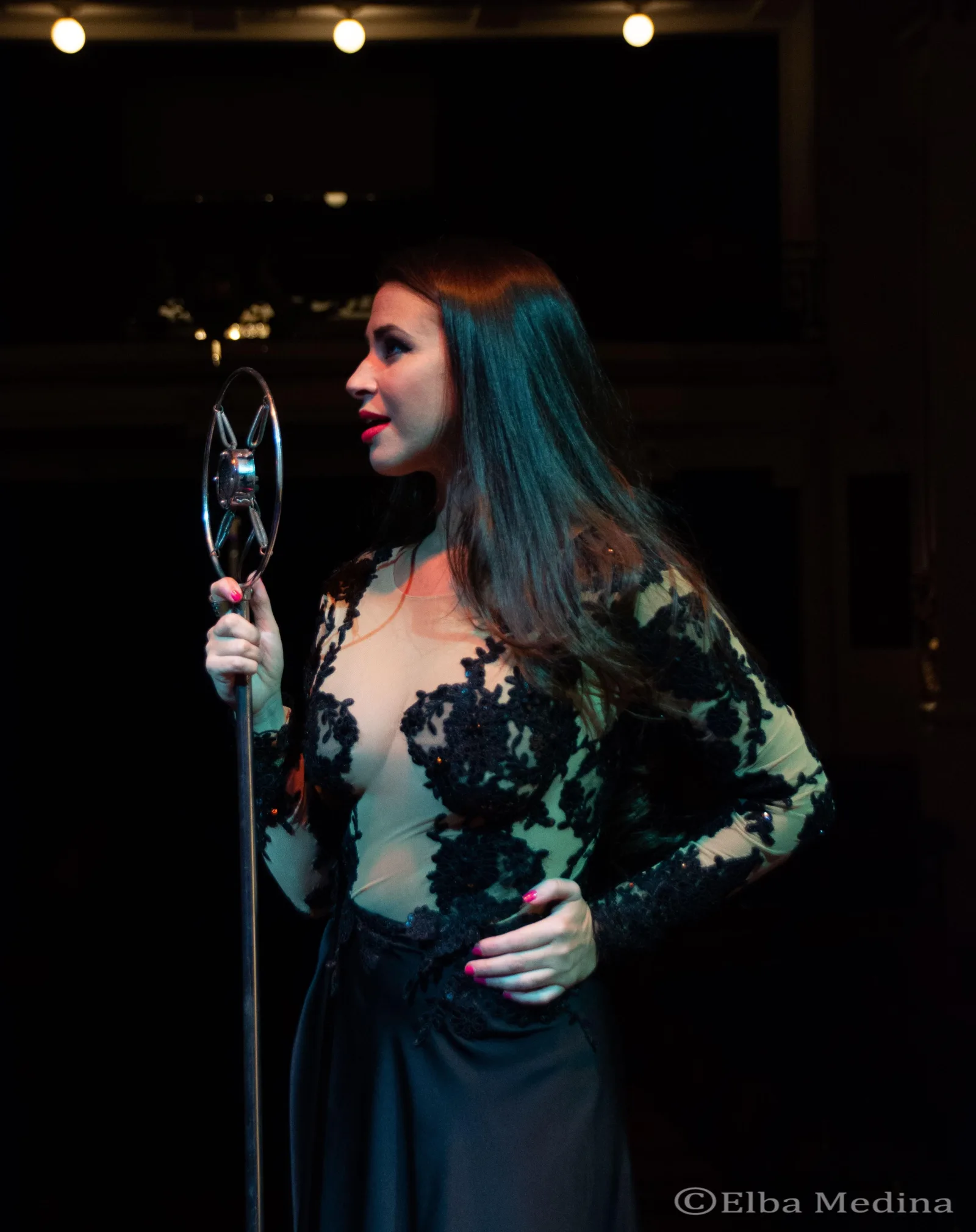 A female tango singer performing in a dark embroidered gown at Piazzolla Tango