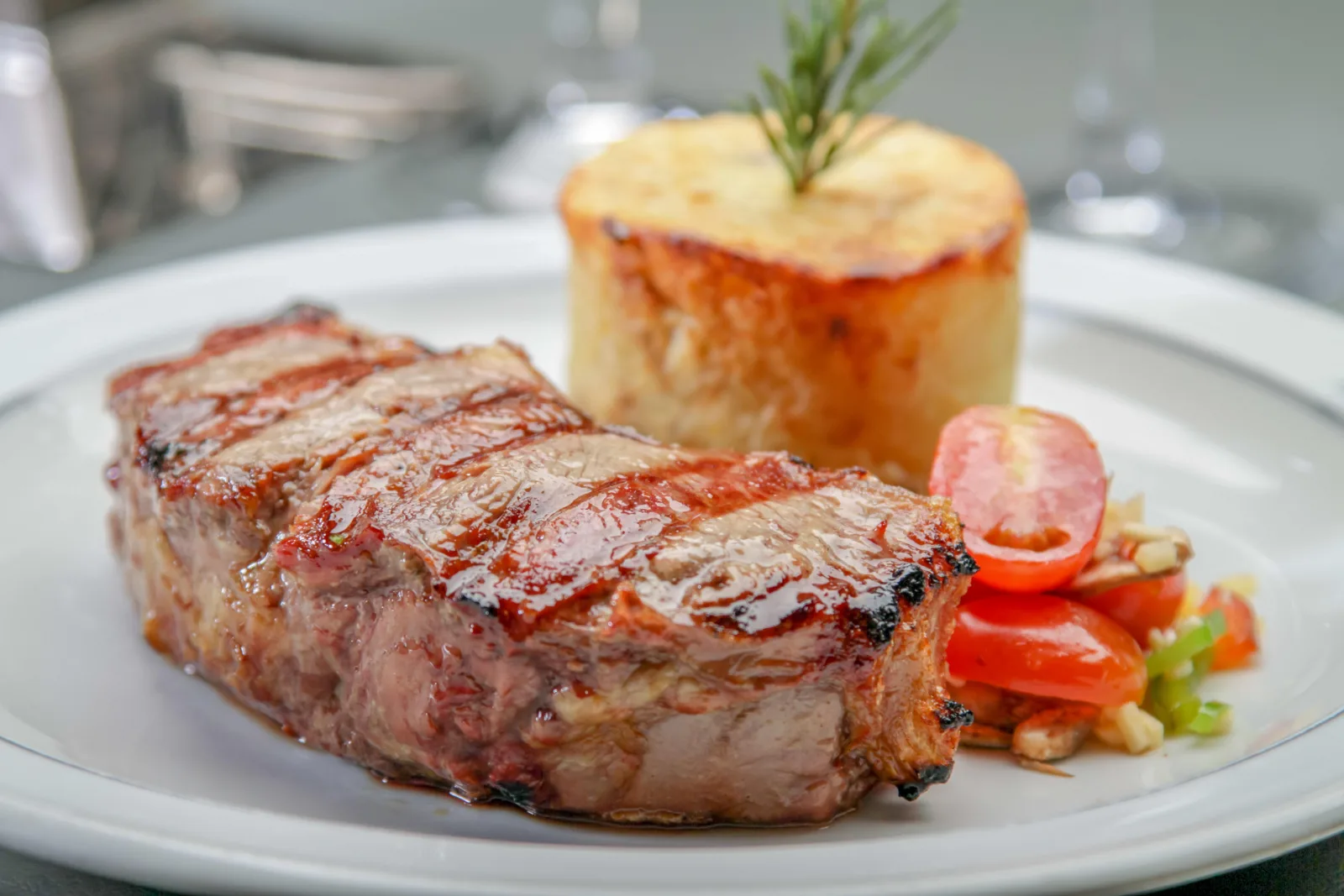 A grilled steak main course plated with potato and vegetables from the Tango Porteño dinner menu