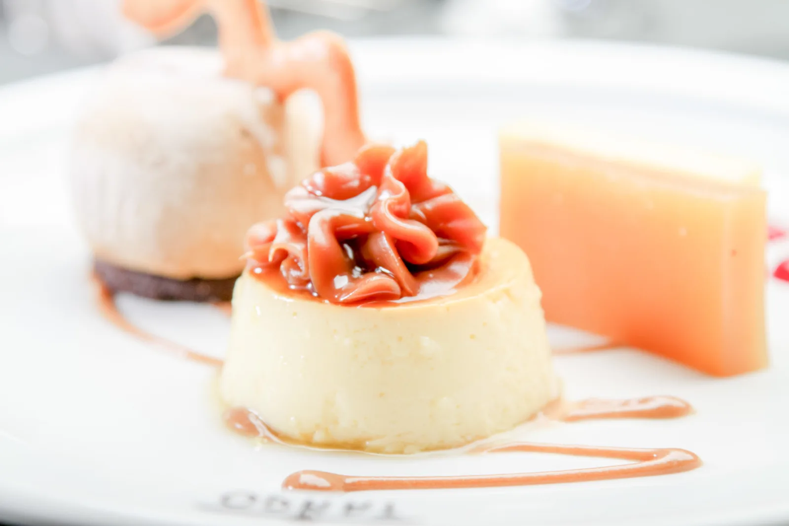 A plated dessert with cream and fruit sauce served at Tango Porteño