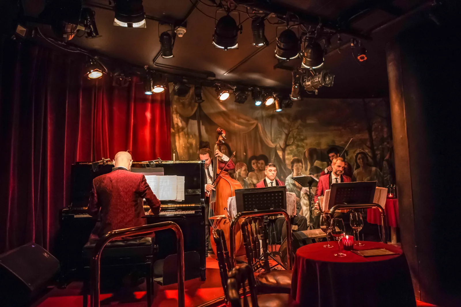 The intimate red-lit Rojo Tango cabaret room with piano, musicians and cabaret tables