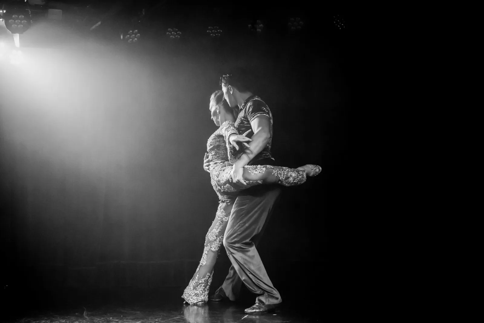 A tango couple dancing in a spotlight at Rojo Tango, shot in black and white