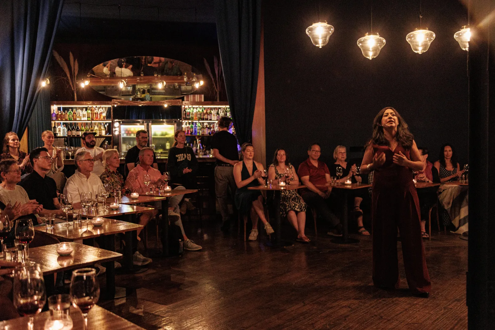 A singer performing to a seated audience in the intimate Secreto Tango room