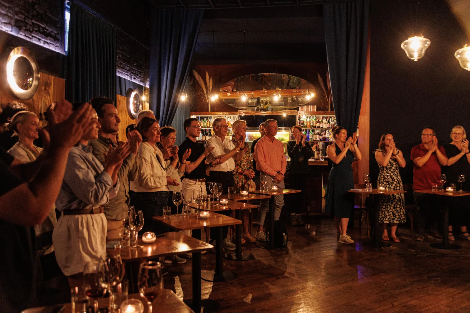The Secreto Tango audience applauding at close range in the warm-lit venue